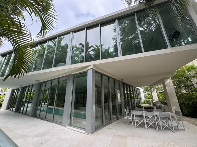 Casa terminada con ventanas y puertas de impacto de piso a techo junto a la piscina