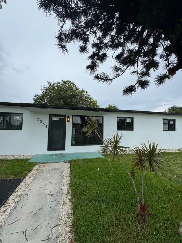 Casa de un piso con ventanas y puerta de impacto de marco negro recién instaladas